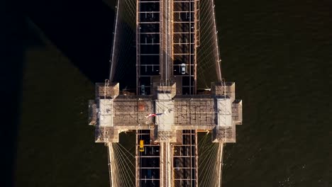 Vista-aérea-superior-del-puente-de-Brooklyn-en-Nueva-York,-América.-Drone-volando-por-encima-del-East-river-y-el-tráfico-por-carretera