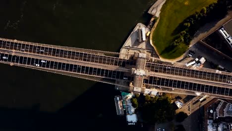 Aerial-top-view-of-Brooklyn-bridge.-Drone-turning-around-the-shore-of-East-river-in-Brooklyn,-New-York,-America