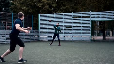 Zwei-Männer-üben-American-Football-auf-Feld