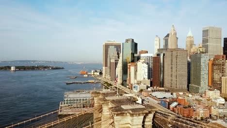 Vista-aérea-de-Manhattan-en-Nueva-York,-América.-Drone-volando-sobre-el-río-del-este,-puente-de-Brooklyn-y-que-agitan-en-la-bandera-de-viento