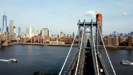 Aerial-view-on-Manhattan-bridge-in-New-York,-America.-Drone-flying-over-the-East-river,-boat-riding-through