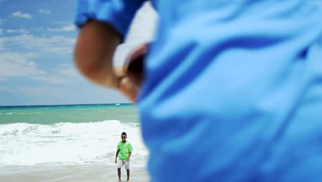 African-American-boys-playing-American-football-on-beach