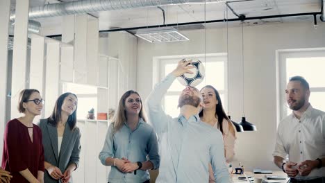 Happy-Caucasian-worker-juggling-football-on-head.-Cheerful-mixed-race-executives-celebrate-business-success-in-office-4K