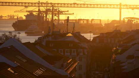 Lisbon,-Portugal.-Bridge,-harbor-and-traffic-on-Rua-do-Arsenal-in-sunset-lights.-Tilt-shot