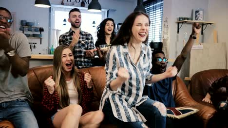 Los-aficionados-al-fútbol-y-multiétnica-celebran-ganar.-Slow-motion-4K.-Los-fanáticos-van-loco-viendo-juego-de-deportes-en-la-TV.-Emoción