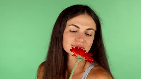 Wunderschöne-Frau-lächelnd-Blick-verträumt,-entfernt-die-eine-Blume