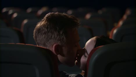 Los-jóvenes-se-besan-apasionadamente-en-la-sala-de-cine-vacía.-Amor-pareja-besos