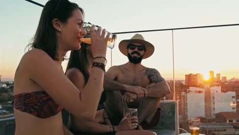 hombre-y-mujer-jóvenes-disfrutando-de-una-cerveza-y-la-compañía-en-un-bar-de-la-azotea-sobre-la-ciudad-con-vista-hermosa-con-un-lindo-perro-de-animal-doméstico