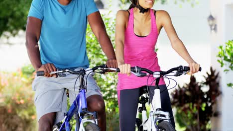 Pareja-étnica-sano-ciclismo-para-mantener-ajuste-al-aire-libre