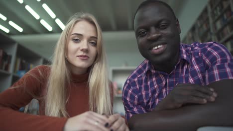 African-american-male-and-european-female-talk-to-camera-in-the-library