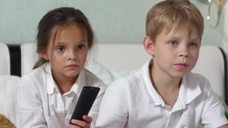 Kids-Sitting-on-Bed-and-Watching-TV