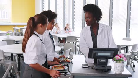 Estudiantes-de-secundaria-con-uniforme-pagar-comida-en-cafetería