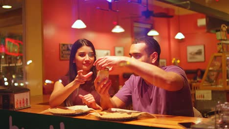 Una-joven-pareja-comiendo-en-un-centro-de-la-ciudad-de-pizzeria