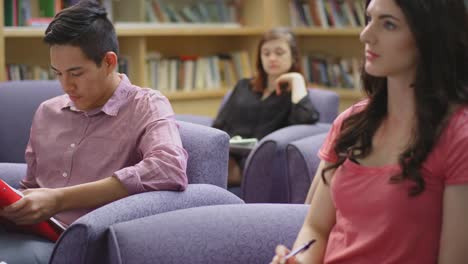 A-student-using-his-phone-in-class-pretends-to-be-taking-notes