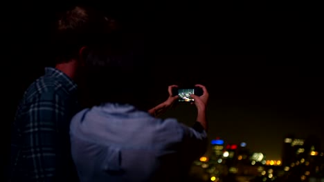 Pareja-feliz-tomando-imagen-de-la-ciudad-desde-el-último-piso