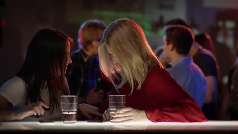 Zwei-schöne-Mädchen-in-der-Bar-im-Verein-Reden-und-lachen