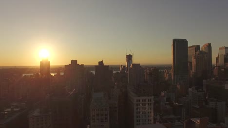 Descending-Shot-During-Sunset-Creating-Illusion-Of-Sun-Hiding-Behind-Building