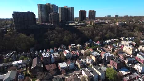 Cliffside-Park,-NJ-fliegen-über-Häuser-in-Richtung-Mehrfamilienhäuser-mit-blauem-Himmel