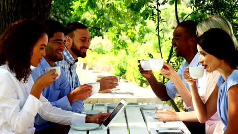 Gruppe-von-Freunden-Toasten-Kaffeetassen-auf-Terrasse