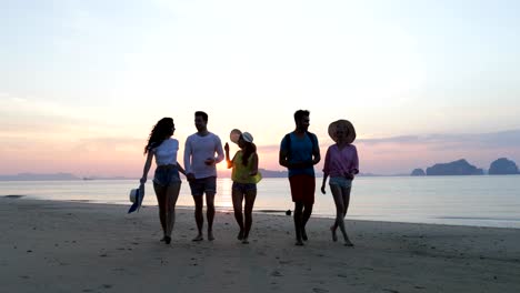 Personas-hablando-en-la-playa-al-caminar-al-atardecer,-comunicación-del-grupo-de-jóvenes-turistas