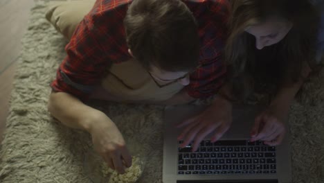 Young-Couple-are-Laying-on-the-Floor-and-Using-Laptop.-Casual-Lifestyle.