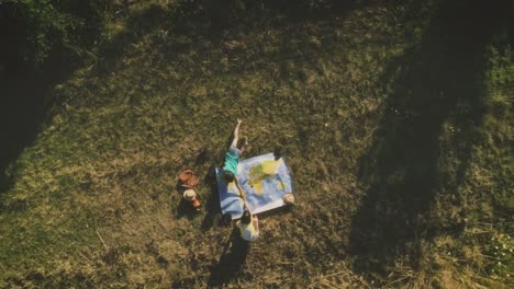 Jóvenes-chicas-jugando-con-el-mapa-del-mundo-en-campo-verde