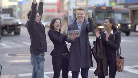 Young-Gender-Mixed-Diverse-Group-of-Friends-Using-Digital-Tablet.-Talking,-Discussing-und-Cheering-in-the-City.