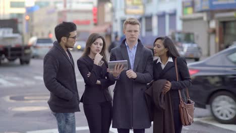 Young-Gender-Mixed-Diverse-Group-of-Friends-Using-Digital-Tablet.-Talking,-Discussing-und-Cheering-in-the-City.