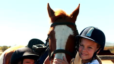 Siblings-touching-the-brown-horse-in-the-ranch-on-a-sunny-day-4k