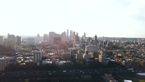 Vista-aérea-del-barrio-de-Brooklyn-en-Nueva-York,-América-en-la-puesta-de-sol.-Drone-volando-sobre-el-tráfico-por-carretera