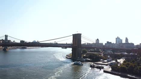 Aerial-view-of-the-Brooklyn-bridge-through-the-East-river-from-Brooklyn-district.-Drone-flying-over-the-traffic-road
