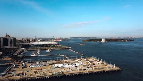 Vista-aérea-de-la-orilla-de-East-river-en-Nueva-York,-América.-Drone-volando-a-lo-largo-de-la-construcción-en-la-costa-en-Brooklyn