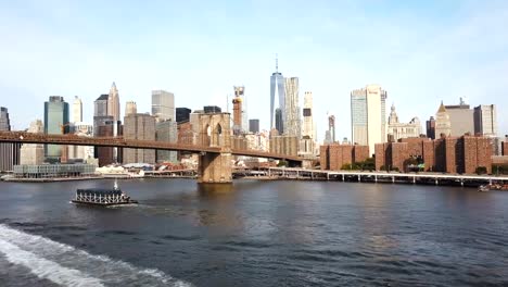 Aerial-view-of-Brooklyn-bridge-going-to-Manhattan-in-New-York,-America.-Drone-fly-under-the-bridge-through-East-river