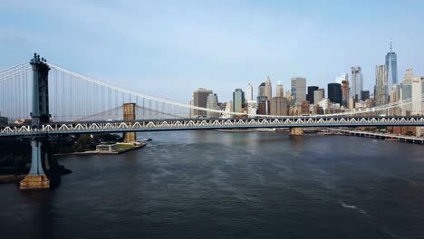 Aerial-view-of-the-Manhattan-bridge-through-the-East-river.-Drone-flying-near-the-road-in-New-York,-America