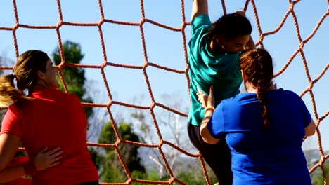 Women-practicing-net-climbing-during-obstacle-course