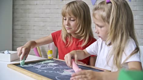 Cute-Girls-Drawing-with-Chalk-on-Blackboard