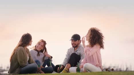 Gruppe-von-schönen-jungen-Leuten-draußen-zu-sitzen-und-Spaß-haben