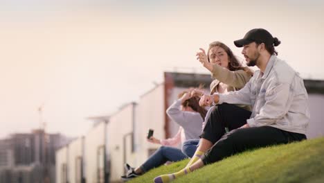 Group-of-young-people-on-a-meadow-while-one-Girl-is-pointing-a-Finger-at-something