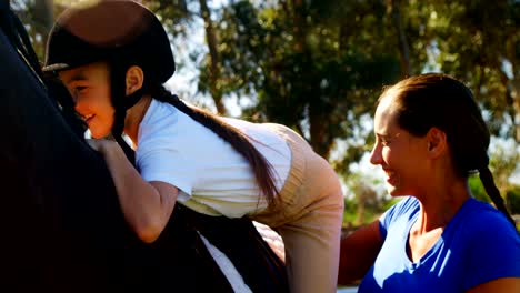 Mother-assisting-daughter-during-horse-riding-4k