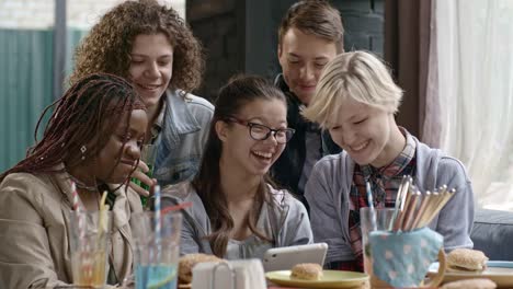 Teens-Having-Fun-while-Using-Tablet-at-Lunch