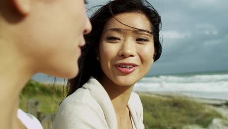 Multi-ethnischen-Freundinnen-zusammen-fallen-Strand-lachen