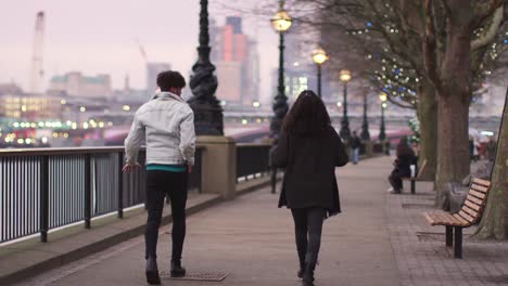 Rückansicht-des-Paares-zu-Fuß-entlang-dem-Südufer-auf-Besuch-in-London