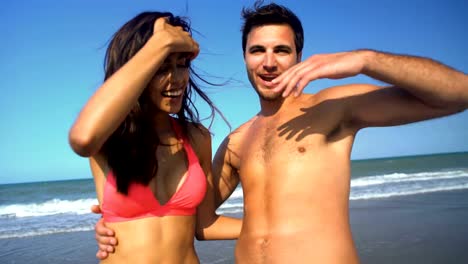 Portrait-of-smiling-multi-ethnic-couple-in-swimwear