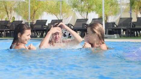 Guy-jump-in-swimming-pool-between-two-girls