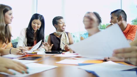 Multi-ethnic-teenagers-sitting-with-female-college-lecturer