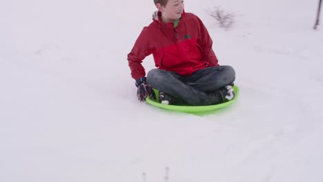 Junge-im-Winter-Schnee-bedeckten-Hügel-hinunter-rodeln