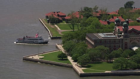 Toma-aérea-de-ferry-dejando-a-Ellis-Island.