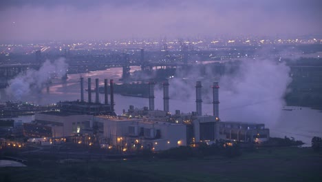 Flying-by-industrial-area-with-power-plant-in-early-morning.