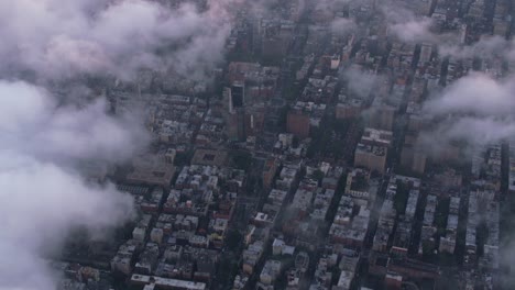 Aerial-view-looking-through-low-clouds-at-Manhattan.