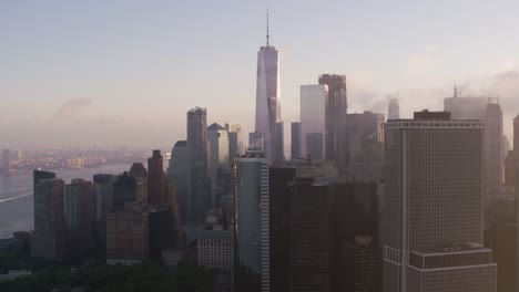 Verfolgung-durch-niedrigere-Manhattan-Gebäude-mit-niedrigen-Wolken-und-Sonne-am-frühen-Morgen.